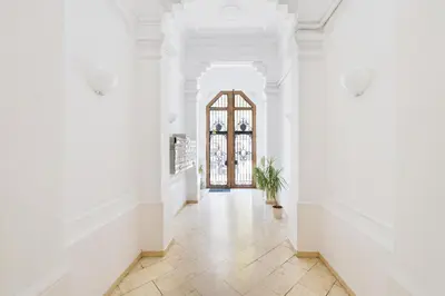 a hallway with white walls and a large window at Apartamento Rambla Catalunya in Barcelona