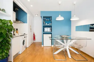 a kitchen with a glass table and blue walls at Apartamento Rambla Catalunya in Barcelona