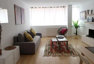a living room with a couch and a table at Apartments BCN Central-Montjuic in Barcelona