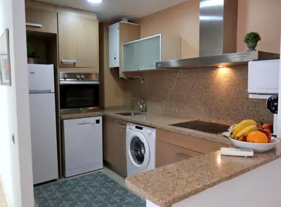 a kitchen with a bowl of fruit on a counter at Apartments BCN Central-Montjuic in Barcelona