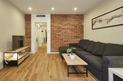 a living room with a couch and a brick wall at BBarcelona Sagrada Familia Flats in Barcelona