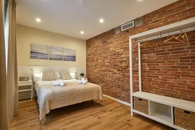 a bedroom with a bed and a brick wall at BBarcelona Sagrada Familia Flats in Barcelona