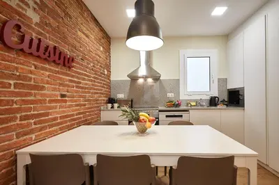 a kitchen with a white table and a brick wall at BBarcelona Sagrada Familia Flats in Barcelona