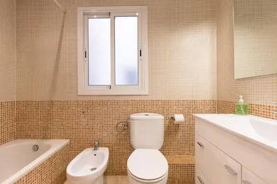 a bathroom with a toilet and a tub and a sink at ApartEasy - Plaza España & Fira in Barcelona