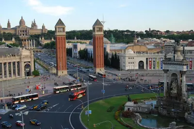 a city with buses and cars on a street at ApartEasy - Plaza España & Fira in Barcelona