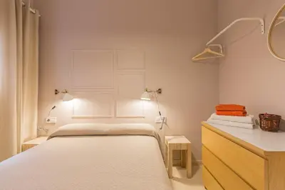 a bedroom with two beds and a dresser with a mirror at ApartEasy - Plaza España & Fira in Barcelona