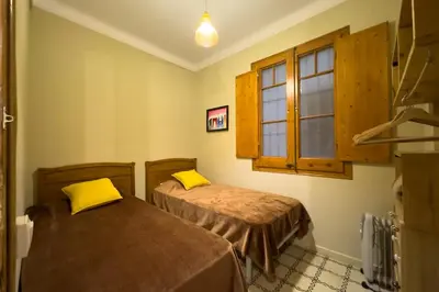 two beds in a room with a window at ApartEasy - Gracia Apartments in Barcelona