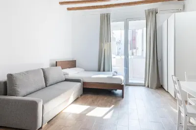 a living room with a couch and a table at Homenfun Barcelona Studio Camp Nou II in Hospitalet de Llobregat