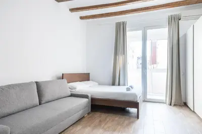 a living room with a couch and a bed at Homenfun Barcelona Studio Camp Nou II in Hospitalet de Llobregat