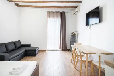 a living room with a couch and a table at Homenfun Barcelona Studio Camp Nou II in Hospitalet de Llobregat