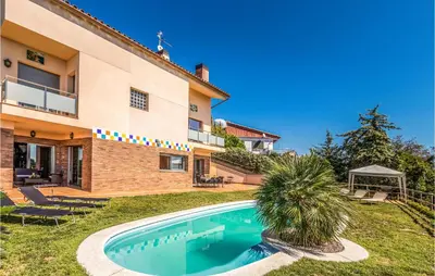 a villa with a swimming pool in front of a house at Lovely Home In Sant Cebrià De Vallalta in San Cipriano de Vallalta