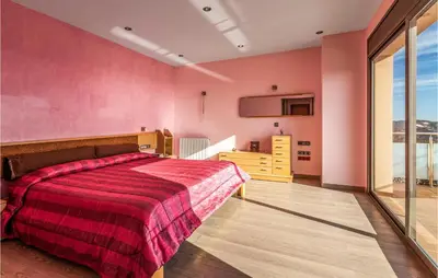 a bedroom with pink walls and a bed with a red blanket at Lovely Home In Sant Cebrià De Vallalta in San Cipriano de Vallalta