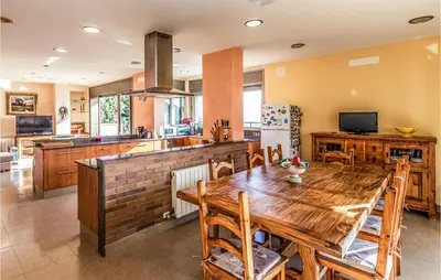 a kitchen and dining room with a wooden table at Lovely Home In Sant Cebrià De Vallalta in San Cipriano de Vallalta