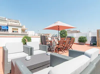 a patio with a table and chairs and an umbrella at Picasso Suites in Barcelona