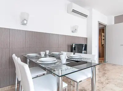 a dining room with a glass table and white chairs at Picasso Suites in Barcelona