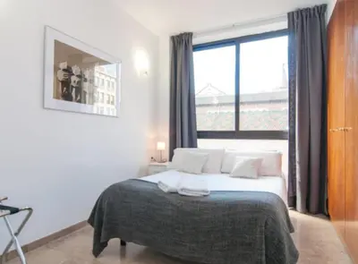 a bedroom with a white bed and a large window at Picasso Suites in Barcelona