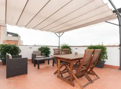 a patio with a wooden table and chairs at Picasso Suites in Barcelona
