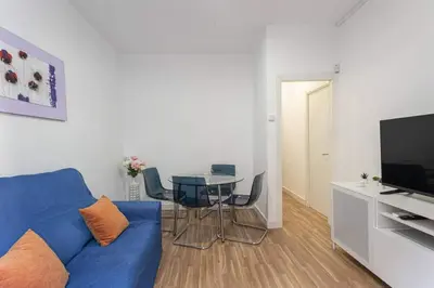 a living room with a blue couch and a table at Bright 3bdr Near To The Metro in Hospitalet de Llobregat