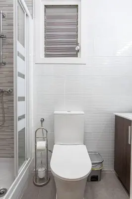 a white bathroom with a toilet and a window at Bright 3bdr Near To The Metro in Hospitalet de Llobregat