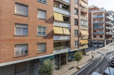 an empty street in front of a brick building at Bright 3bdr Near To The Metro in Hospitalet de Llobregat