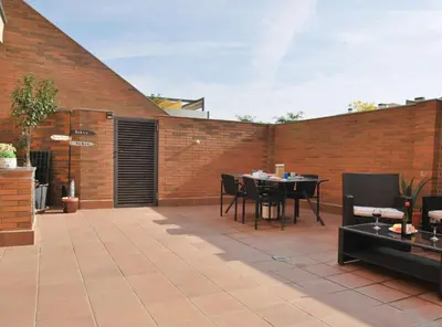a patio with a table and chairs and a brick wall at Home Pool and Beach in Cabrera de Mar