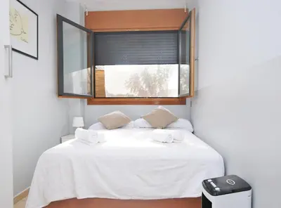 a bedroom with a white bed with a window at Home Pool and Beach in Cabrera de Mar