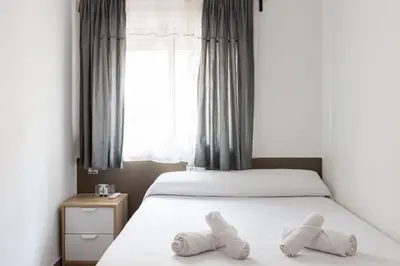 a bedroom with two beds with towels on them at Pensión Galicia in Canovellas