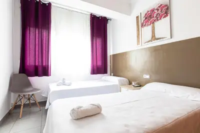 a hotel room with two beds and a window at Pensión Galicia in Canovellas