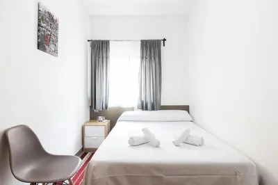 a hotel room with a bed and a chair at Pensión Galicia in Canovellas