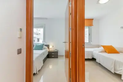 a bedroom with two beds and a mirror at Fragata Sitges Rentals in Sitges