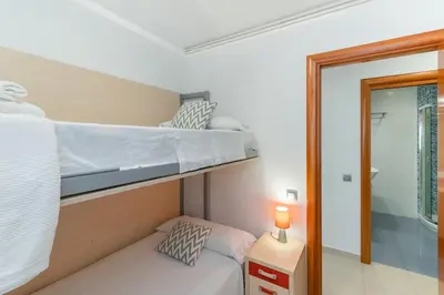 a bedroom with two bunk beds and a mirror at Fragata Sitges Rentals in Sitges