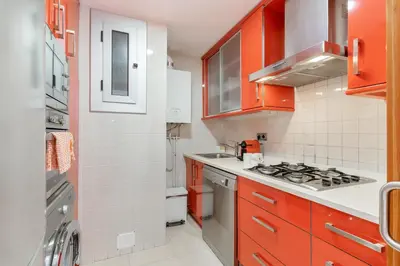 a kitchen with orange cabinets and a stove top oven at Fragata Sitges Rentals in Sitges