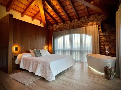 a bedroom with a bed and a bath tub at Alojamiento MAS EL CASTELL DEL BRULL B&B in El Brull