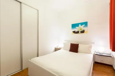 a white bedroom with a white bed and a window at Stay U-nique Apartments Lope de Vega in Barcelona