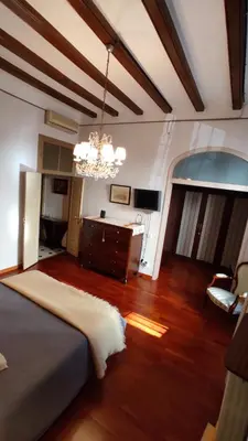 a bedroom with a bed and a chandelier at Casa MO in Sabadell