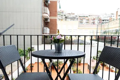 a table with a vase of flowers on a balcony at AB Eixample Calabria in Barcelona