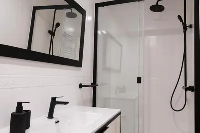 a bathroom with a shower and a sink and a mirror at AB Eixample Calabria in Barcelona