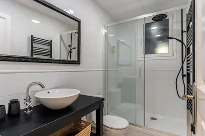 a white bathroom with a sink and a shower at AB Eixample Calabria in Barcelona