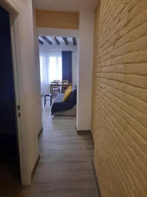 a hallway leading to a living room with a couch at Apartaco Apartamentos in Sitges