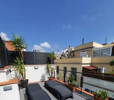 a balcony with palm trees and a building at Apartaco Apartamentos in Sitges