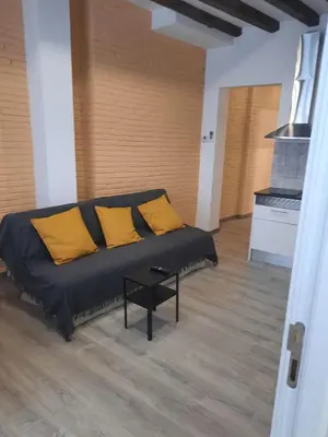 a couch with yellow pillows in a living room at Apartaco Apartamentos in Sitges