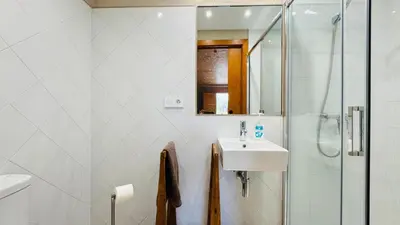 a white bathroom with a sink and a shower at Apartment with private pool and garden in San Martín Sarroca