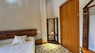 a bedroom with a bed and a wooden door at Apartment with private pool and garden in San Martín Sarroca