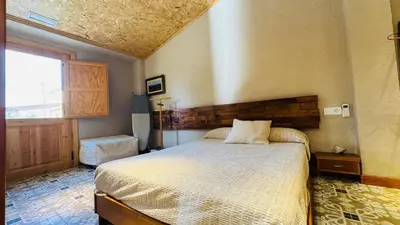 a bedroom with a bed and a large window at Apartment with private pool and garden in San Martín Sarroca