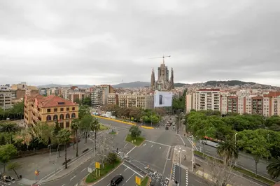 a white bedroom with a bed and a table at AB Sagrada Familia Views in Barcelona