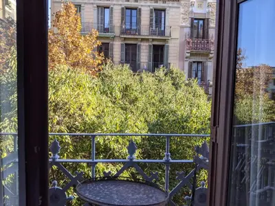a balcony with a table and a view of a building at Period Luxury Apartment in Barcelona Prime Location with Street View in Barcelona