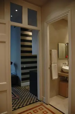 a bathroom with a sink and a mirror and a door at Period Luxury Apartment in Barcelona Prime Location with Street View in Barcelona