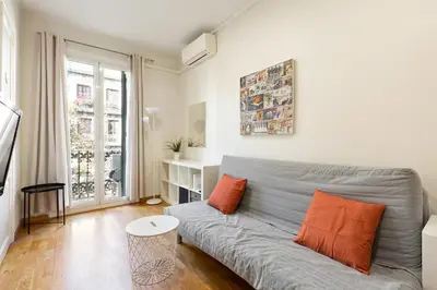 a living room with a gray couch and orange pillows at Stay U-nique Apartments Consell in Barcelona
