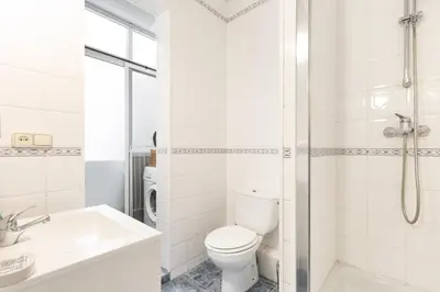 a white bathroom with a toilet and a sink at Stay U-nique Apartments Consell in Barcelona