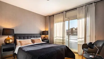 a bedroom with a bed and a chair and a window at HOSTAL BEDMATES in Barcelona
